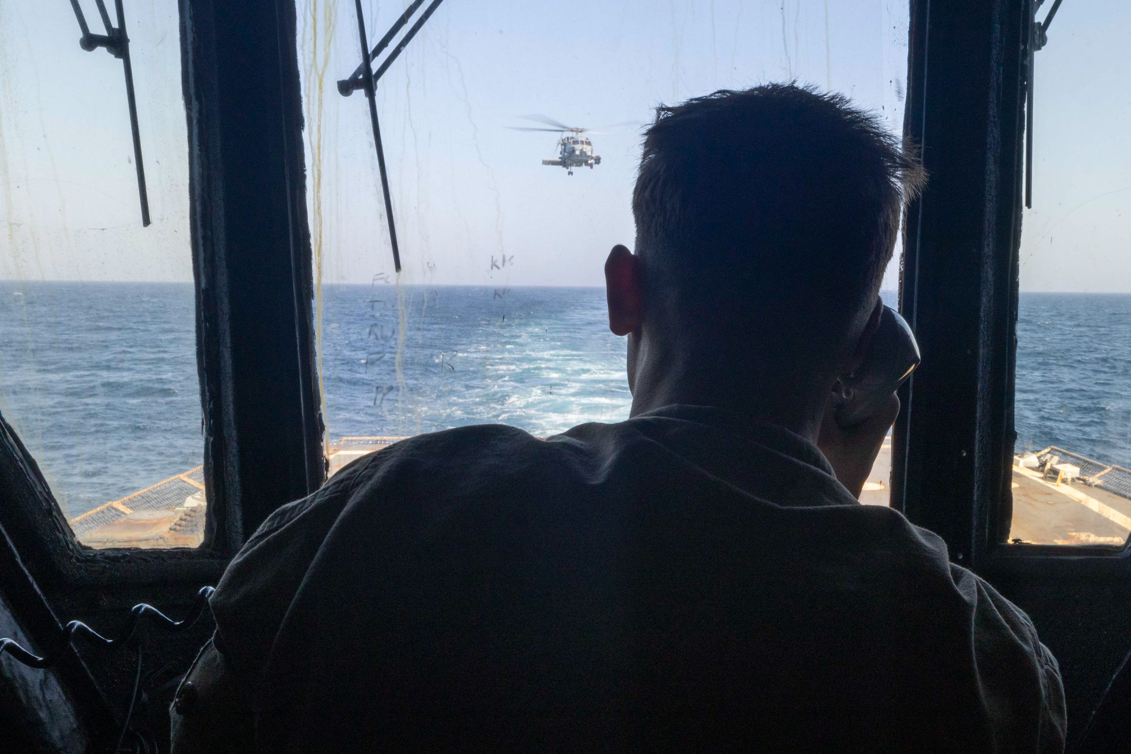@U.S. Central Command: A U.S. Sailor standing watch aboard guided-missile destroyer USS Michael Murphy (DDG 112) observes flight operations in the Arabian Sea as 🇺🇸 American forces enforce the naval blockade. As of today,