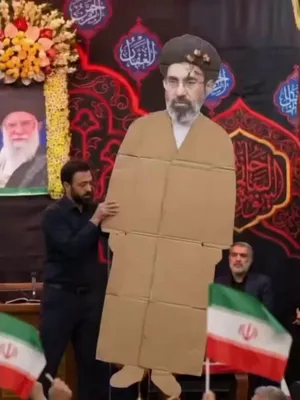@Visegrád 24: Iran’s newly appointed Supreme Leader, Mojtaba Khamenei, was presented at a mass rally in Tehran today.

He couldn’t show up in person for some reason, so they brought out a cardboard cutout of him in