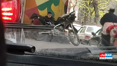 @ايران اينترنشنال: The image received by Iran International shows a Basij agent in Tehran who, on the evening of Thursday, March 18, took shelter under a bridge out of fear of an Israeli drone attack.