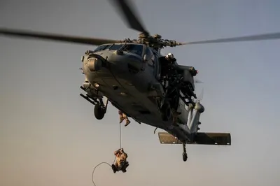 مارین‌های امریکا از هواپیлот دستی از هواپیمای MH-60S Sea Hawk پایین می‌آیند در حالی که در روی پلاکه پروازی ناوشکن USS Tripoli (LHA 7) در تاریخ 8 مه تمرین می‌کنند. این تمرین مطمئن می‌کند که مارین‌های امریکا در آمادگی مانند باقی بمانند، اگر نیاز به عملکرد داشته باشند.