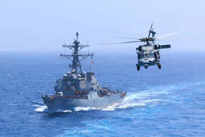 @U.S. Central Command: USS Donald Cook (DDG 75) transits the Arabian Sea while an MH-60S Sea Hawk flies nearby. American forces continue to strictly enforce the ongoing naval blockade against Iran. As of July 18, CENTCOM ha